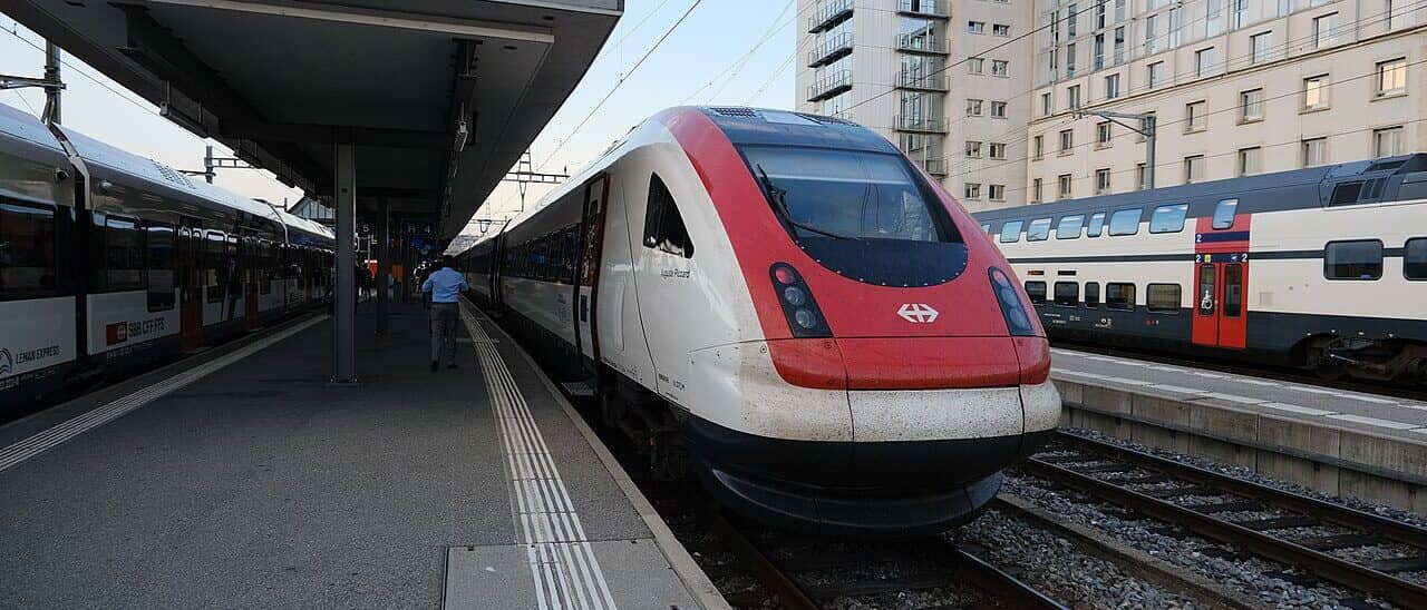 Quai de la gare de Genève-Cornavin — un train intercités CFF à l’arrêt, un voyageur sur le quai.