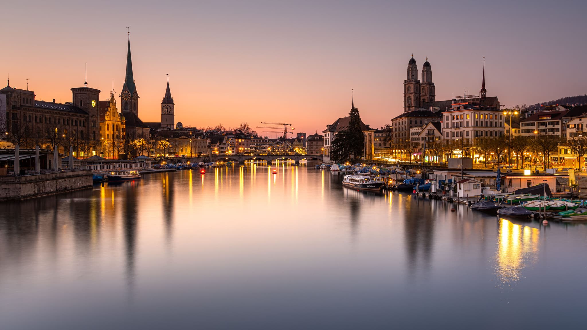 Zürich old town and the Limmat at sunset, with the towers of the Grossmünster, Fraumünster and St. Peter.